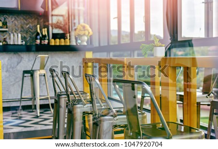 Modern Interior of Cozy Coffee Bar with Large Open Window Glass. Clean Table .Empty Slate Frames for Text Copy Space.Cafe Pub with Yellow Furniture During Day Background.