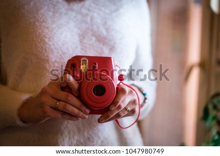 Female holding retro instant camera