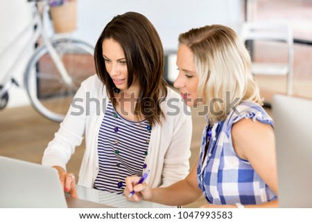 Image of two young business women in office