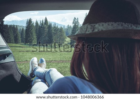 Summer road trip car vacation concept. Woman legs out he car. Conceptual freedom, travel and holidays image.