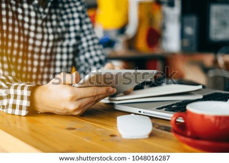 designer man using smart phone for mobile payments online shopping,omni channel,sitting on table,virtual icons graphics interface screen in morning light
