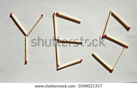 YES word made of matches on a white paper background