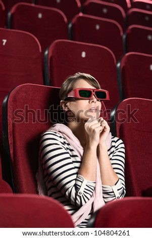 Young woman watching a horror at the cinema