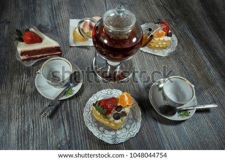 tasty tea drinking .cupcake with strawberries and tangerines, cream on the table  