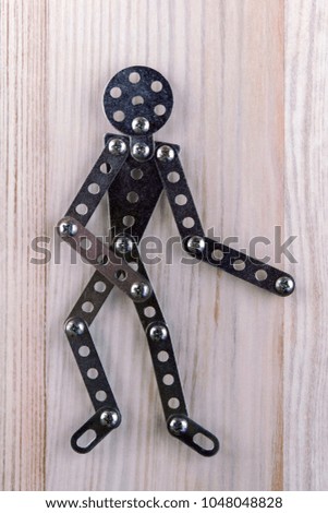 man icon for recreation room: man made of designer stands, politely inviting us to pass, light wooden background