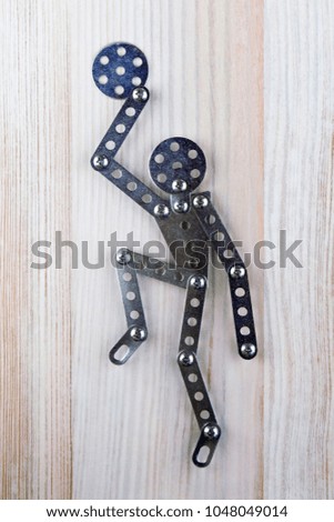 man icon for recreation room: man made of designer plays with ball, light wooden background