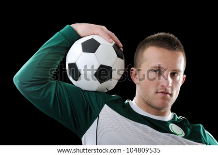 Proffessional footballer holding a ball on his shoulder
