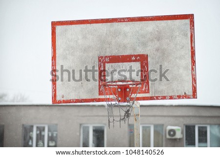 Basketball ring on an old basketball shield on a winter day street