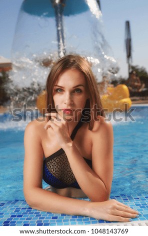 Beautiful, young brown-haired woman with a gorgeous figure in the pool