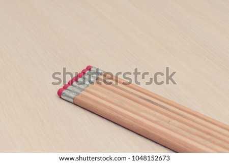 
simple pencils with a red-colored elastic band lie on the table