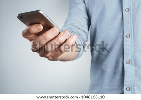 Hand holding black smartphone on white background