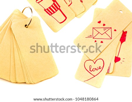 set of recycled label tags tied with a metal ring to a notepad isolated on white background with scattered labels with pink drawings