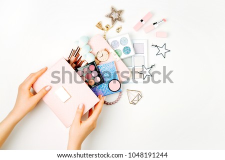 Female hands hold Makeup bag with cosmetic beauty products. Flat lay, top view. Beauty and Fashion concept Royalty-Free Stock Photo #1048191244