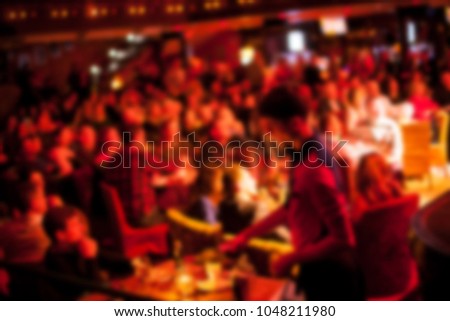 People are watching a concert of classical / jazz / blues music. blurred young and adult women and men and other people who are watching while listening to a concert of pop music in a concert hall