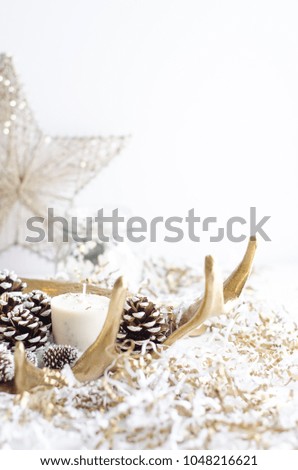 antler candle with pine cones and confetti gold and white christmas holiday decor on white background