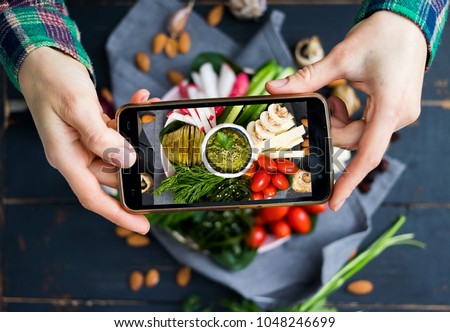 Woman hands takes food photo of mixed healthy veggie buddha bowl with vegetables and avocado chickpea dip. Make food photography for social networks on mobile smartphone. Raw, vegan, vegetarian food Royalty-Free Stock Photo #1048246699