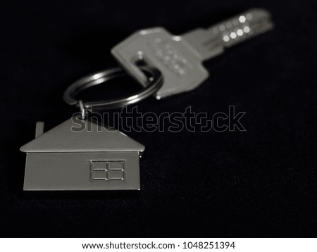 home key and metal key ring in the shape of a house