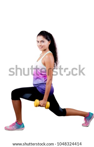 Portrait of Indian woman holding a dumbbell while warming up before workout, isolated on white background