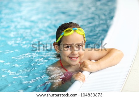 Cute girl with goggles in swimming pool