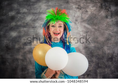 Young cheerful girl in a colorful pony horse costume with balloons. Animator, costume show, a carnival. Bright image for the poster, bright cheerful card. April fool's day
