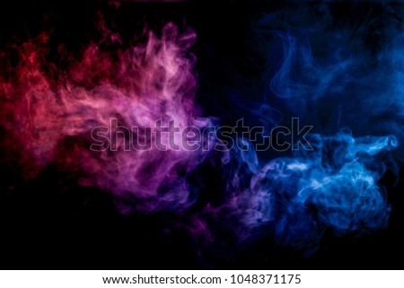 Dense multicolored smoke of pink and   blue  colors on a black isolated background. Background of smoke vape