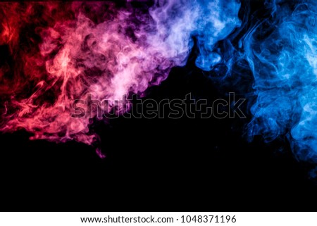Thick blue and pink colorful smoke of on a black isolated background. Background from the smoke of vape