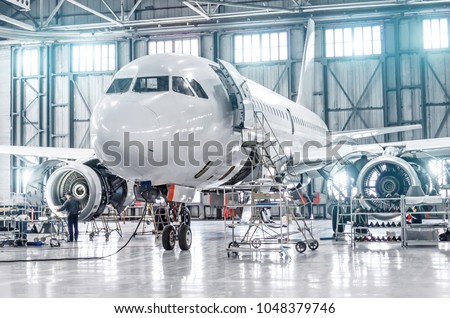 Passenger aircraft on maintenance of engine and fuselage repair in airport hangar Royalty-Free Stock Photo #1048379746