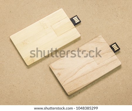 Flash drive card on brown cardboard texture background.  USB stick made from wood material concept.
