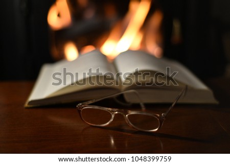 
Old Reading Glasses On Old Book And Fireplace 