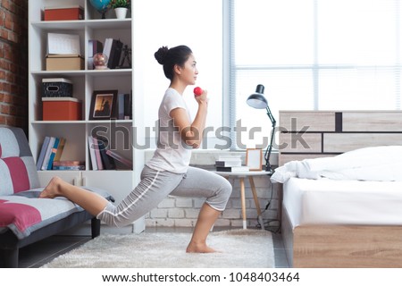 Asian women exercising in bed in the morning, she feels refreshed.She acts as squat. Royalty-Free Stock Photo #1048403464