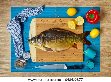 Fresh carp, vegetables on a blue background