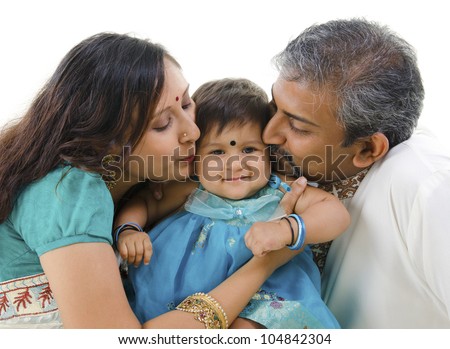 Indian parents giving their daughter a kiss, isolated on white background