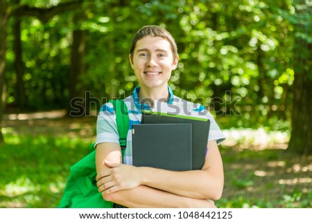 Image of happy man with laptop, books and backpack