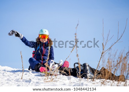 Photo of sportswoman in helmet sitting at snowdrift
