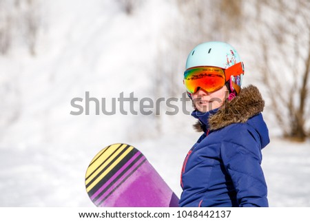 Portrait of sporty woman wearing helmet with snowboard