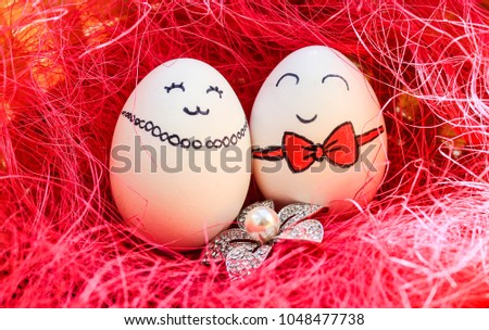 Two white easter eggs with painted faces
