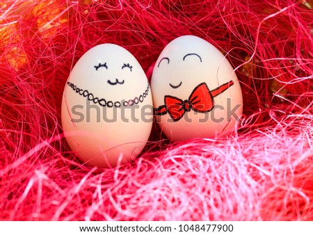 Two white easter eggs with painted faces