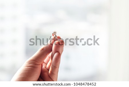 hand hold diamond ring with blur city background. symbol of wedding, marriage and love. image for background, wallpaper, objects and illustration.