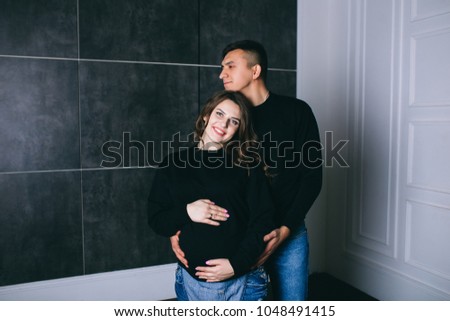 Husband hugs a pregnant wife