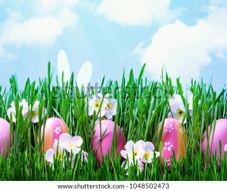Easter Background with easter eggs and spring flowers on green grass
