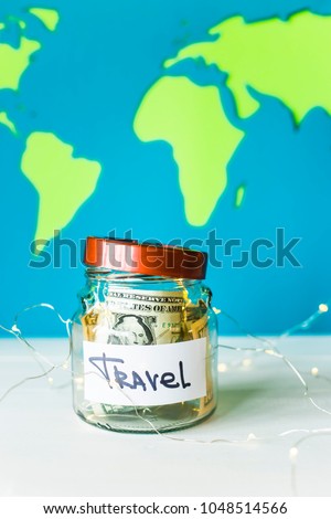 Piggy bank for travel with dollars and garland on a background of a bright world map. Money for travel. Accumulation concept