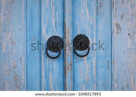 Blue wooden door with metallic door knob handler.