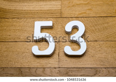 Figures fifty-three on a wooden, parquet floor as a background.