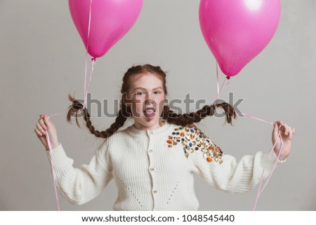red-haired girl in sneakers and beads on the braids holiday