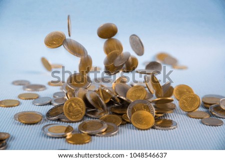 Falling coins money on blue background, business wealth concept idea.