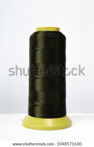 Colored Coil Isolated on a white background with nylon or nylon thread. Photo is ready for online store. Layout. Concept light industry or atelier clothing. spool with green fiber