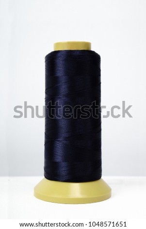 Colored Coil Isolated on a white background with nylon or nylon thread. Photo is ready for online store. Layout. Concept light industry or atelier clothing. spool with blue fiber