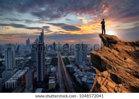 Businessmen stand on high peaks and look to the foreground cityscape, conceptual leader.