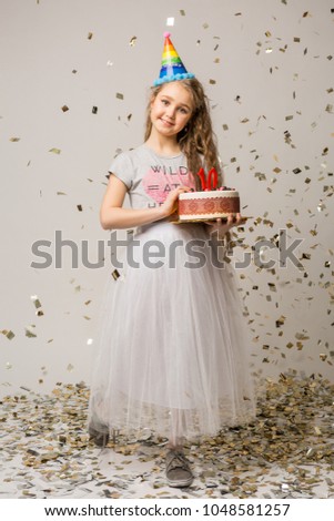young pretty girl celebrating ten years anniversary, birthday party, smiling, happy emotion, positive face expression, long hair, isolated, holding cake with candles, confetti falling, stylish outfit