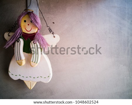 wooden happy doll purple hair hang on the concrete wall has copy space for add text or the article